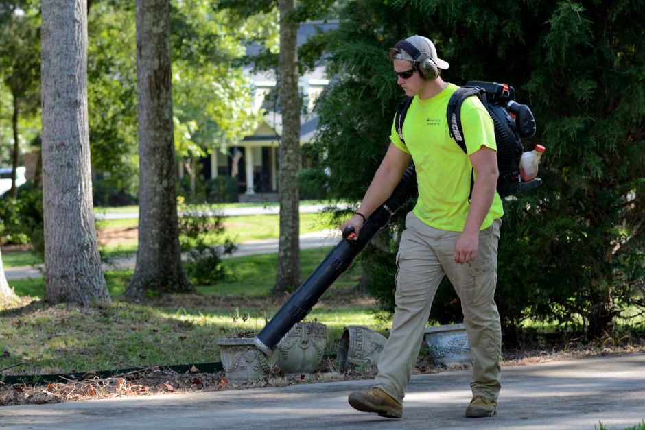 Dedicated lawn care worker smiling on site